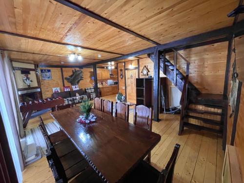 a dining room and living room with a table and chairs at Котедж Chalet Adriana in Bukovel