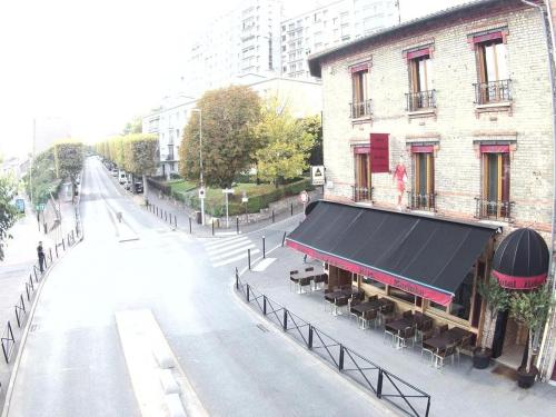 un bâtiment avec un auvent noir dans une rue de la ville dans l'établissement Marinha Hotel, à Gentilly
