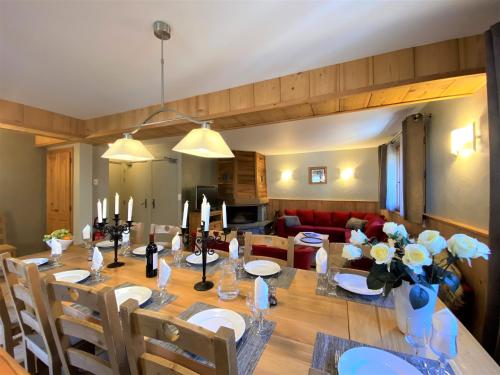 une salle à manger dotée d'une table avec des fleurs et des bougies dans l'établissement Chalet in Morzine sleeping 12 with sauna, à Morzine