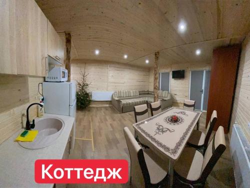 a kitchen and living room with a table and a couch at Вилла Zlata in Bukovel