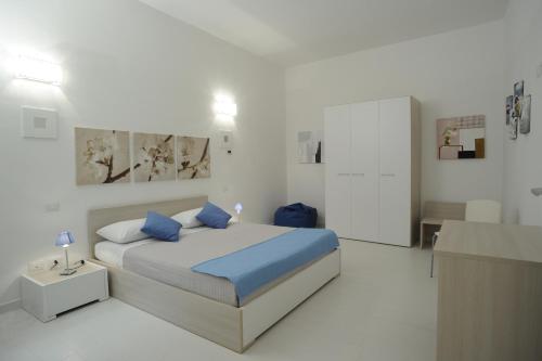 a bedroom with a bed with blue pillows at Italiana Resort in Floridia