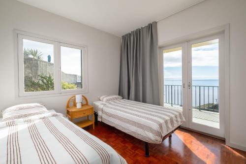 Uma cama ou camas num quarto em Garajau House - Sunrise to Sunset Ocean View Villa