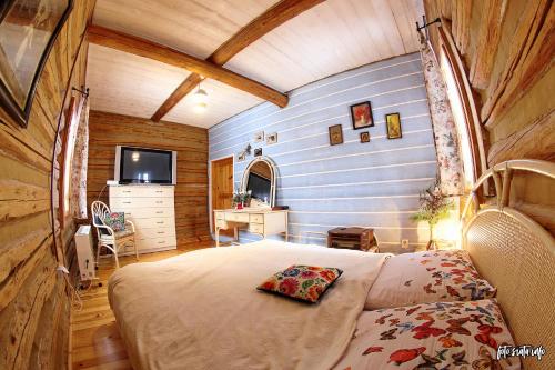 ein Schlafzimmer mit einem Bett und einem TV in einem Zimmer in der Unterkunft Chata z bali -domek w górach ,,Filipkowy Raj''- Limanowa Nowy Sącz Beskidy Kraków in Rozdziele