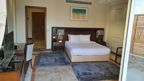 a bedroom with a bed and a desk and a television at Fleet Club Mahrousa in Alexandria