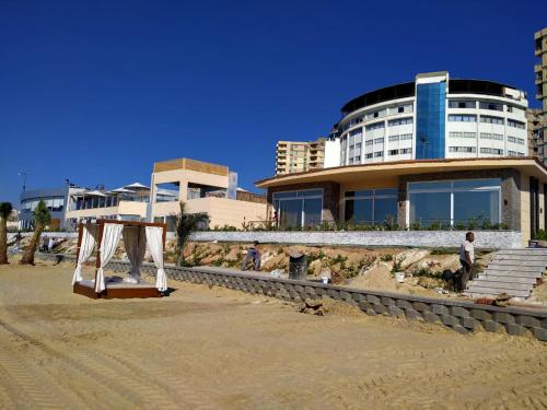 a building on the beach with a tent in the sand at Fleet Club Mahrousa in Alexandria