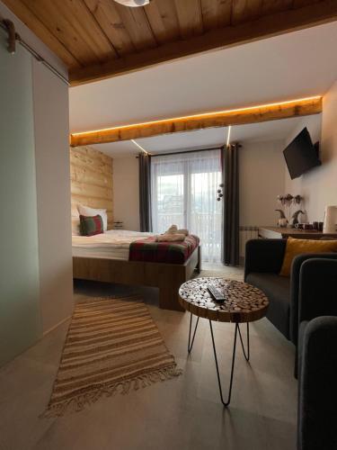 a bedroom with a bed and a couch and a table at Ustup 25 in Zakopane