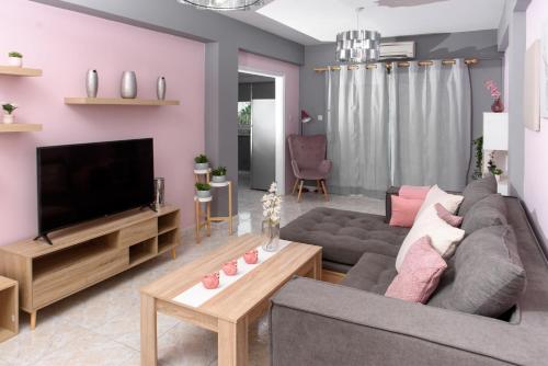 sala de estar con sofá gris y TV de pantalla plana en Callisto 3 Bedroom Apartment en Lárnaca