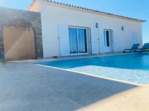 une piscine devant une maison dans l'établissement Les Lauriers Roses villa 2, à Saint-Florent