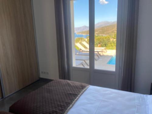 - une chambre avec un lit et une vue sur une terrasse dans l'établissement Les Lauriers Roses villa 2, à Saint-Florent