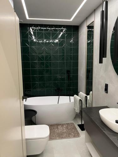 a bathroom with a tub and a toilet and a sink at Apartament Sweet Dream Longinówka in Brodnica