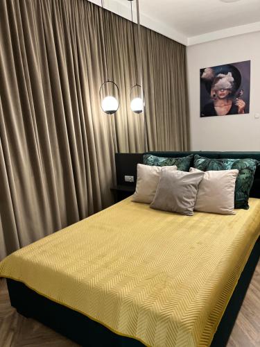 una camera da letto con letto con lenzuola e tende gialle di Apartament Sweet Dream Longinówka a Brodnica
