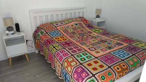 Una cama con una manta colorida encima. en PentHouse con fantástica vista y Amenities únicos, en Punta del Este