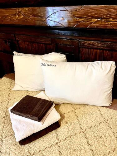 a bed with two white pillows and a towel on it at Котедж Chalet Adriana in Bukovel