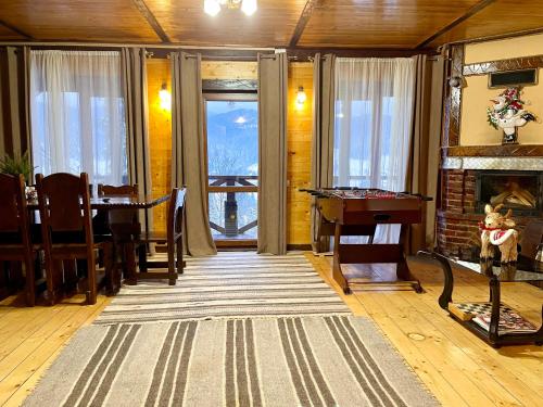 a living room with a fireplace and a table at Котедж Chalet Adriana in Bukovel
