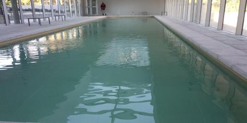 a swimming pool with green water in a building at PentHouse con fantástica vista y Amenities únicos in Punta del Este