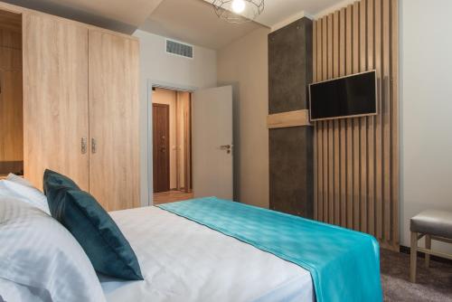 a bedroom with a bed and a television in it at Green Luxury Apartments in Burgas City