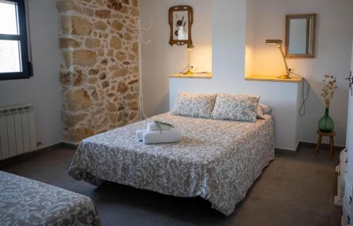 um quarto com uma cama e uma parede de pedra em Alojamiento rural La Granja de Las Monjas em Jaén