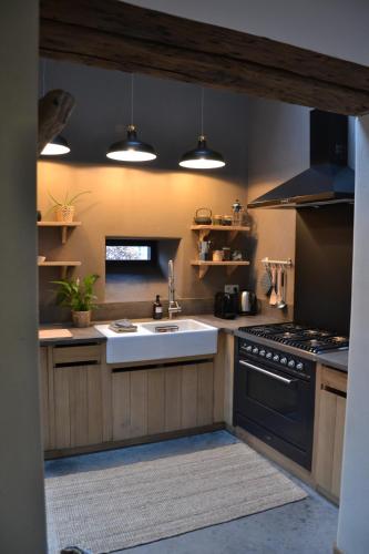a kitchen with a sink and a stove at La petite Reuleau - Gites champêtre "LE FENIL" et "LA FERMETTE SAUNA " in Ciney