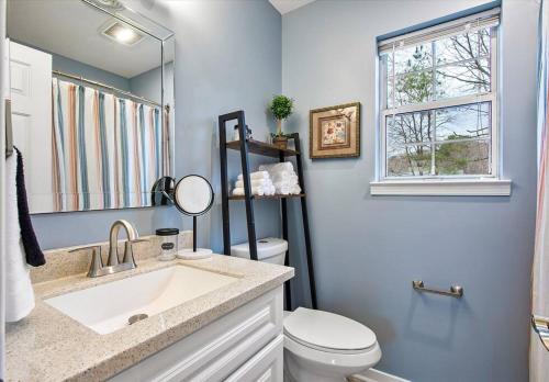 ein Bad mit einem Waschbecken, einem WC und einem Fenster in der Unterkunft Charming 3-Bedroom Home in Heart of Ashland in Ashland