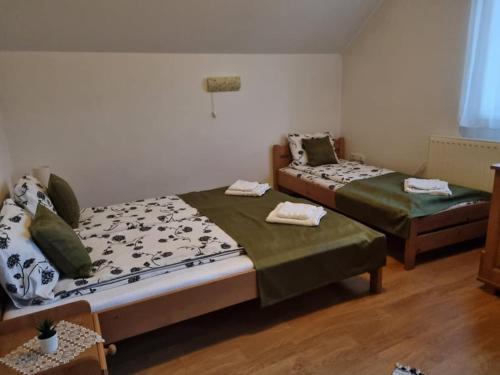a room with two beds and a table in it at Kincses Panzió in Praid