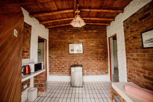 a kitchen with a brick wall and a refrigerator at Hotel Fundo El Arrabal in Ica
