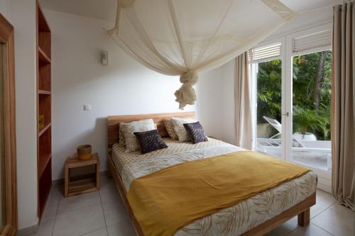 Un dormitorio con una cama y una ventana grande. en Villa l'Amazonia, en Deshaies