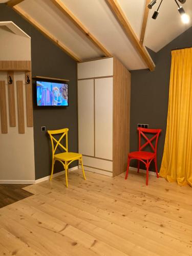 a room with three chairs and a tv on a wall at Borjomi Yellow Hotel in Borjomi