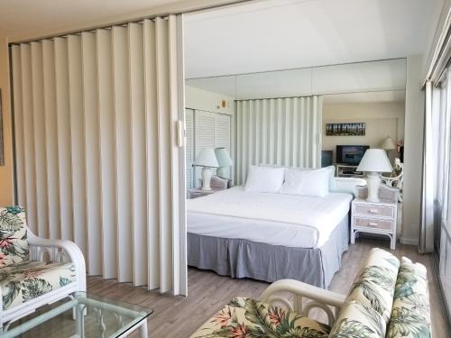 - une chambre avec un lit blanc et un canapé dans l'établissement Ilikai Tower 2136 Lagoon View 1BR, à Honolulu