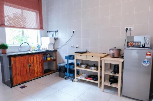 a kitchen with a sink and a refrigerator at Comfy Sofy 21- Backyard Garden- Night Market area in Cameron Highlands