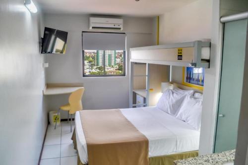 a hotel room with a bed and a desk at Expresso R1 Hotel Economy Suites in Maceió
