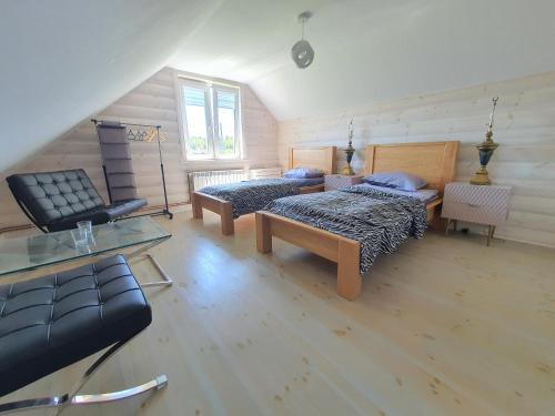 a attic room with two beds and a couch at Zielone Zagrody - Stafieje in Grodzisko Dolne