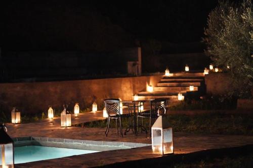 a table and chairs next to a pool at night at ourika oufla in Ourika