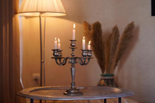 a candle holder with candles on a table next to a lamp at ourika oufla in Ourika