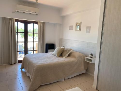 a bedroom with a bed with pillows on it at Oasis del Sur in Puerto Madryn