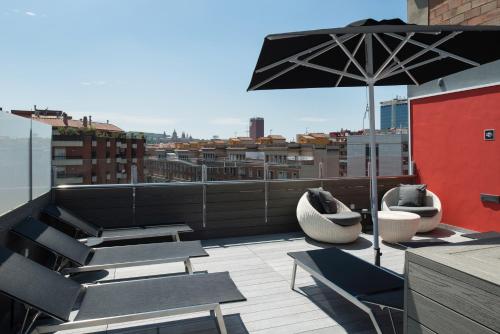 a patio with chairs and an umbrella on a roof at Catalonia Roma in Barcelona