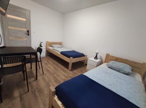 1 dormitorio con 2 camas, escritorio y mesa en Night Point en Racibórz