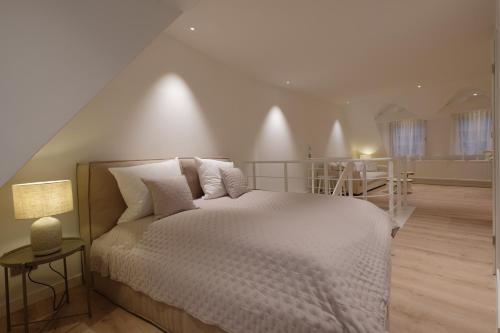 a bedroom with a white bed and a staircase at Boutique Charme Apartment in Baden-Baden