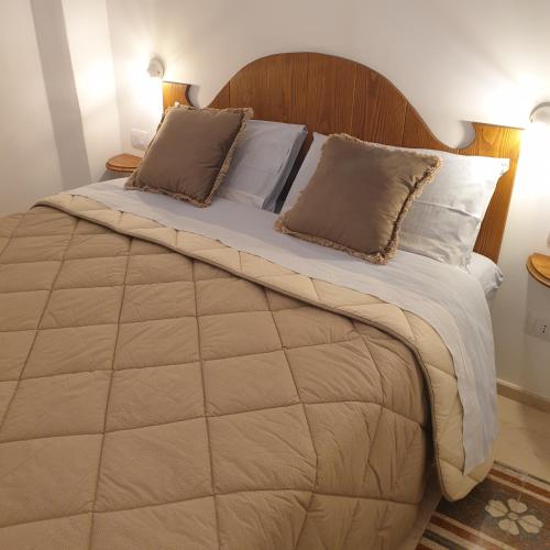 a bedroom with a large bed with a wooden headboard at B&B Dei Cardinale in Bari