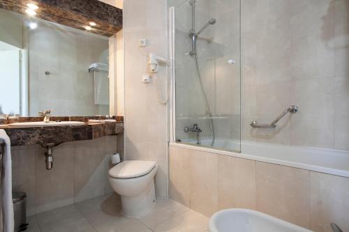 a bathroom with a toilet and a shower and a sink at Crisol Quality Reus in Reus