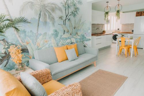 sala de estar con sofá azul y cocina en Triana Natural House 2, en Sevilla