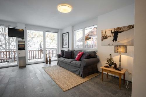 a living room with a couch and a tv at Modern apartment with Matterhorn view in Zermatt