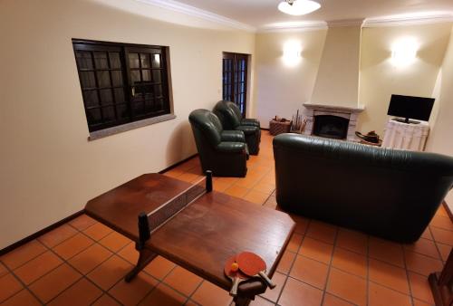 a living room with a couch and chairs and a table at Parada's House in Paredes de Coura