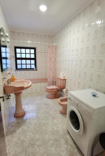 a bathroom with a sink and a washing machine in it at Parada's House in Paredes de Coura