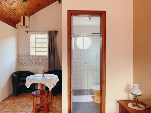 a bathroom with a toilet and a table in a room at Chalés Del Rincon in Monte Verde