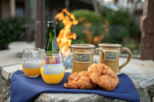 a table with two glasses and a bottle of orange juice at Sea Otter Inn in Cambria