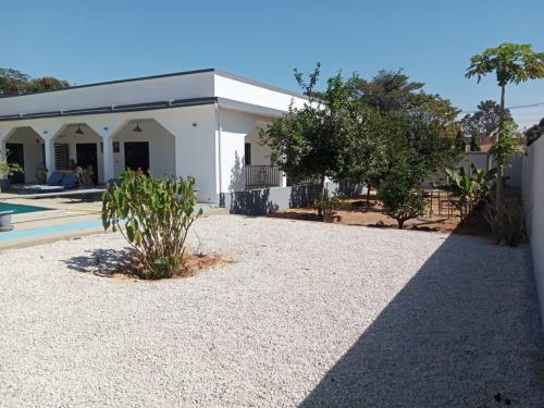 a house with a gravel driveway and a building at La Somonoise in Somone