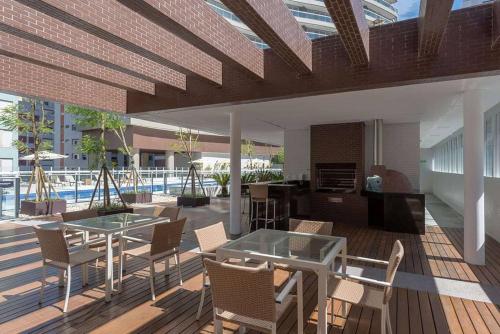 um pátio com uma mesa e cadeiras e uma piscina em Condomínio de Luxo em Frente à Praia (novinho) em Santos
