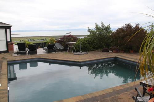 a swimming pool with a view of the ocean at Chartré Manor B&B in Thames
