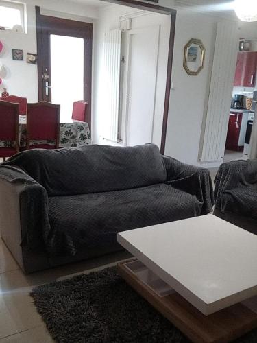 sala de estar con sofá y mesa en La Maison Du Monde, en Tours