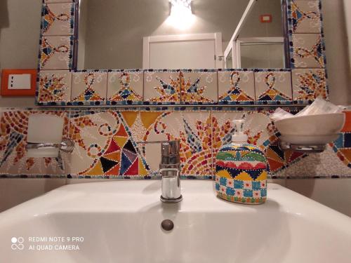 a bathroom sink with a soap dispenser on top of it at Case Vacanza Le Casette in Santo Stefano di Camastra